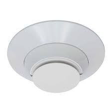 System Sensor 7351 smoke detector mounted on ceiling, black circular smoke alarm with test and hush buttons, for fire safety.