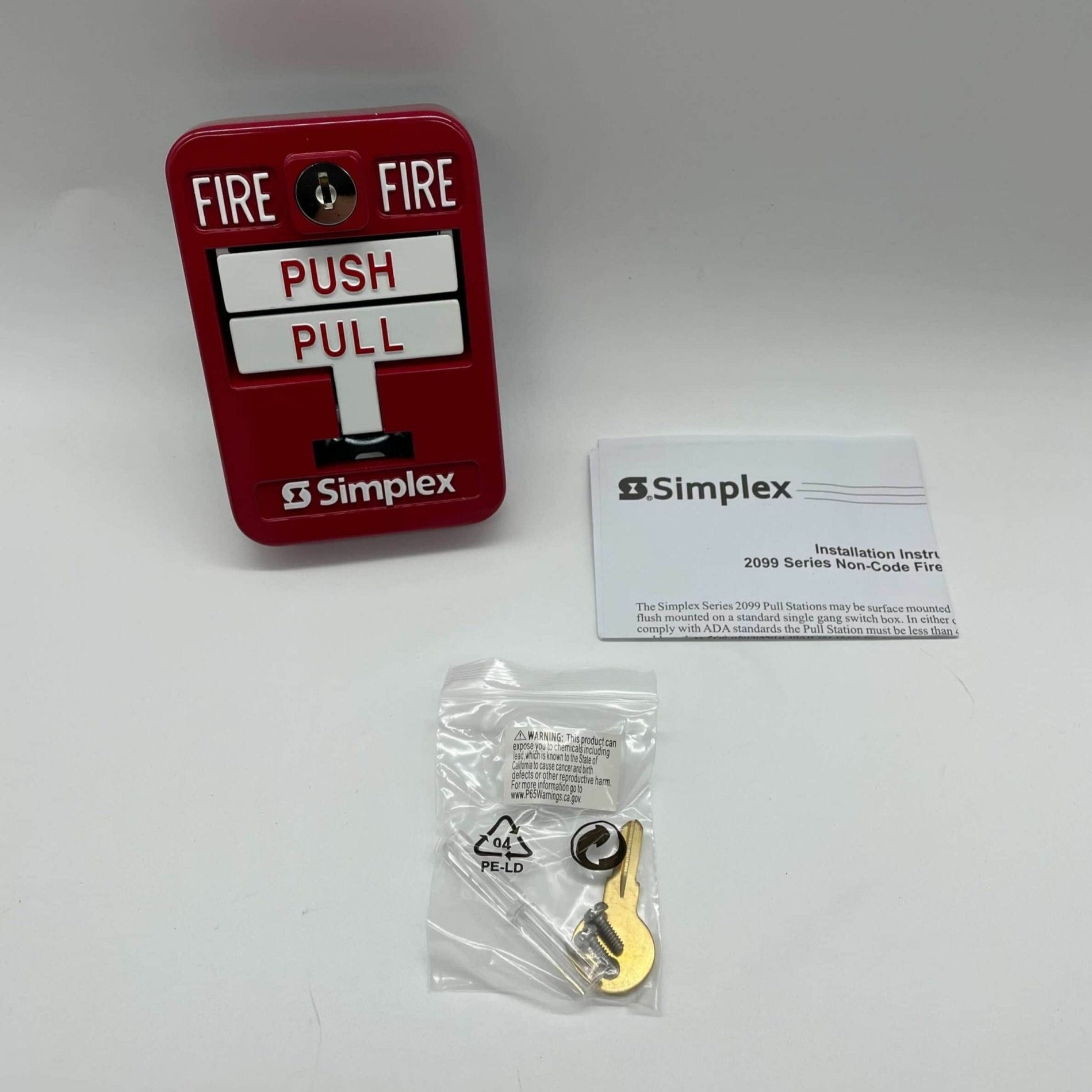 Simplex 2099-9139 manual pull station for fire alarm systems, mounted on wall with clear label and metal casing.